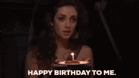 a woman is blowing out a candle on her birthday cake .