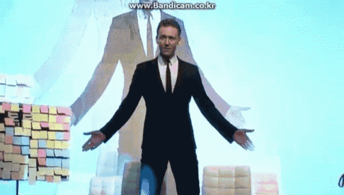 a man in a suit and tie is standing with his arms outstretched in front of a wall with sticky notes on it