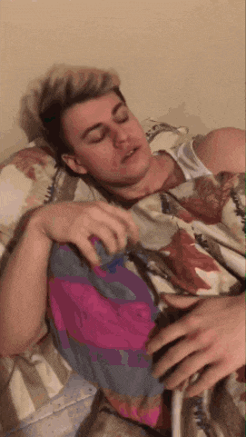 a man laying in bed with his eyes closed and a blanket on his chest