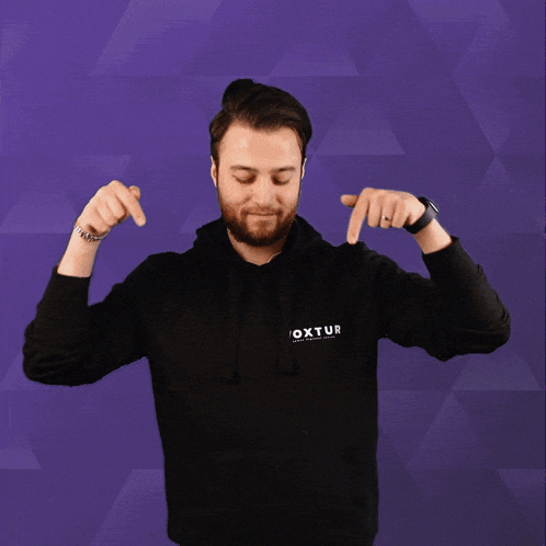 a man wearing a black hoodie with the word oxtur on the front
