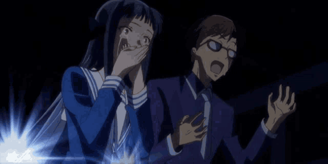 a man and a woman are standing next to each other in the dark