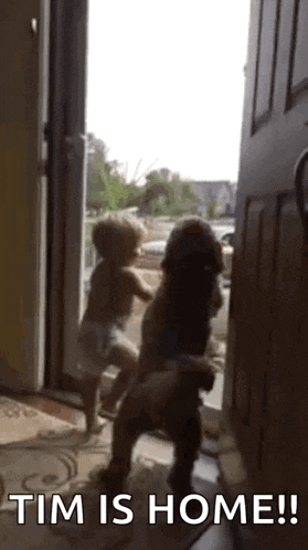 a baby and a dog are standing in an open door .