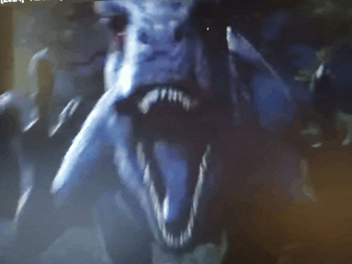 a close up of a monster 's face with a blurred background and a few words visible