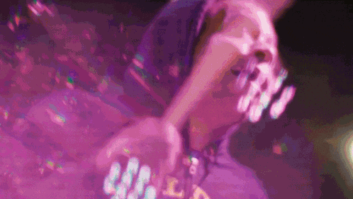 a blurry picture of a person wearing a purple shirt that says ' l.a.p. ' on it