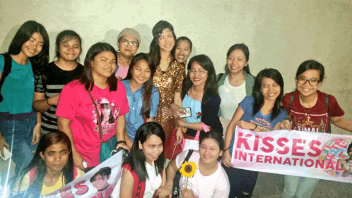a group of young women holding a kisses international sign