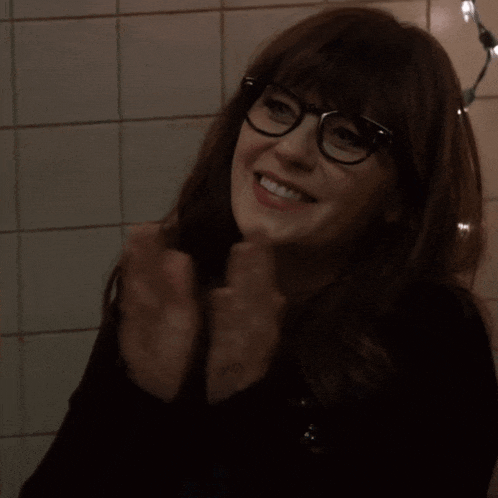 a woman wearing glasses and a black shirt smiles for the camera