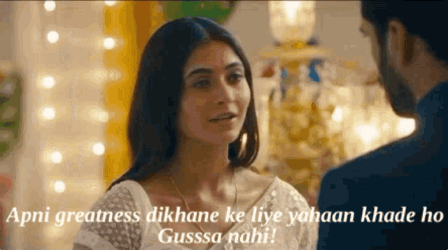 a man and a woman are looking at each other and the woman says apni greatness