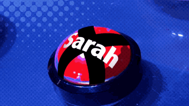 a red button with the name sarah written on it