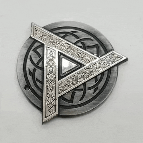a belt buckle with a celtic knot design and a triangle in the middle .
