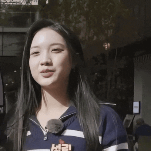 a woman wearing a blue and white striped shirt with the letter l on it