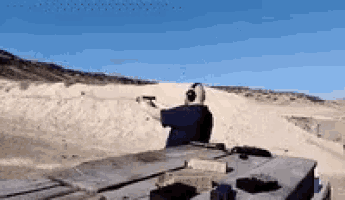 a man is shooting a gun in the desert .