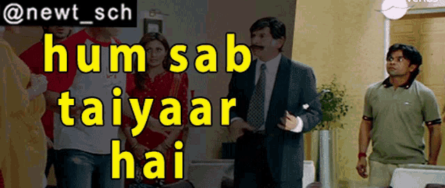 a man in a suit and tie stands in front of a group of people with the words hum sab taiyaar hai above him