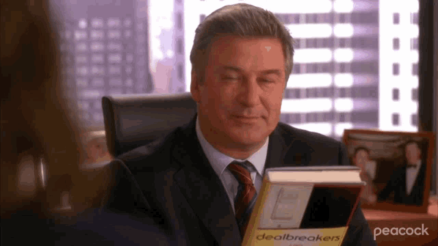 a man in a suit is reading a book called dealbreakers