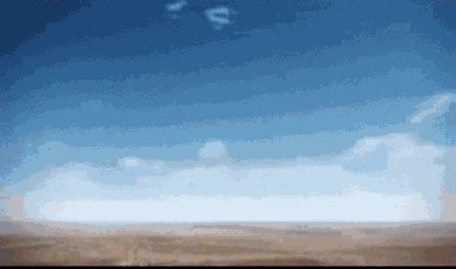 a blue sky with a few clouds and a dollar sign