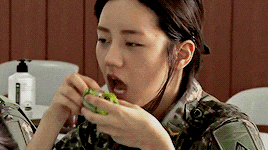 a woman in a military uniform is eating something