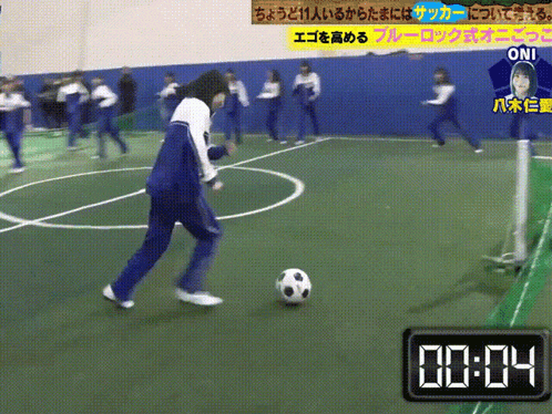 a person kicking a soccer ball on a field with a clock that says 0:04