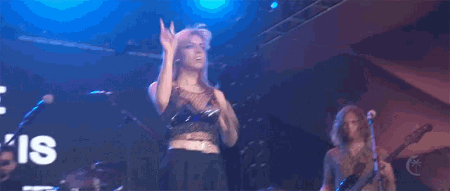 a woman singing on a stage with the word is on the screen