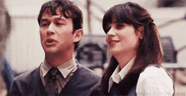 a man and a woman are standing next to each other .