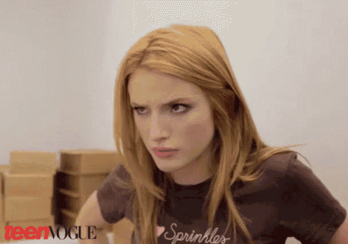 a woman wearing a t-shirt that says sprinkles looks at the camera