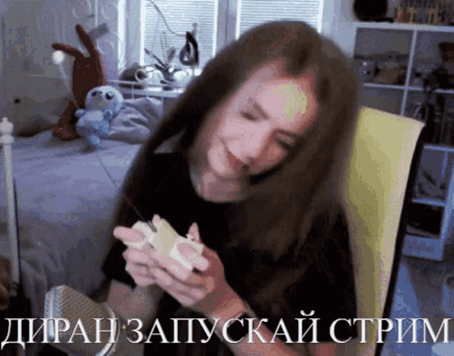 a woman sitting in a chair with russian writing on the bottom of the screen