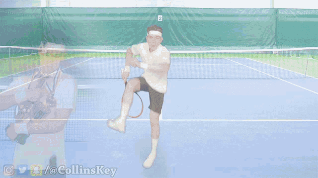 a tennis player is holding a trophy and a tennis ball is hitting him in the face