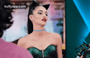 a woman in a cat costume is standing in front of a man .