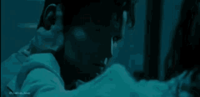 a man and a woman are kissing in a dark room in a movie .