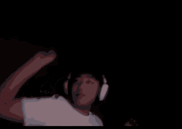 a man wearing headphones is sitting in a dark room .