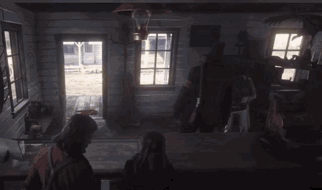 a man and a woman are looking out a window in a cabin