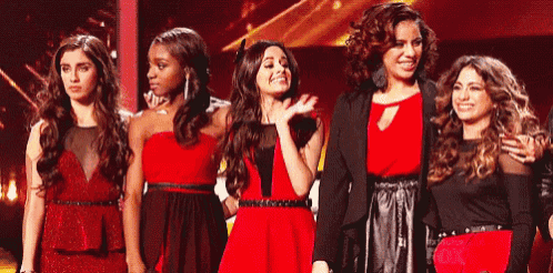 a group of young women are standing next to each other on a stage .