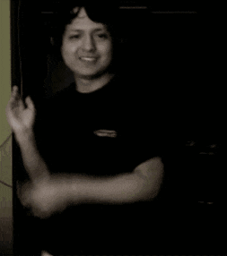 a man wearing a gopro shirt is smiling and covering his face