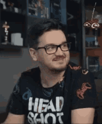 a man wearing glasses and a shirt that says head shot