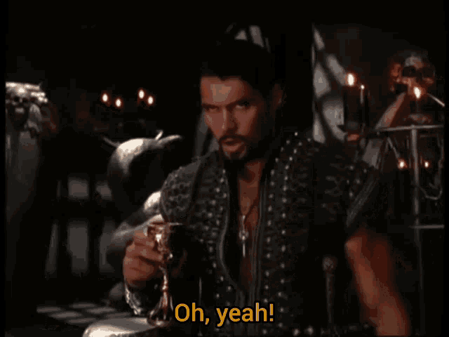 a man with a beard is holding a goblet and saying oh yeah