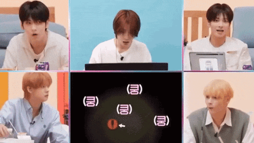 a group of young men are sitting in front of a computer screen with chinese writing on it .