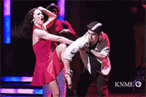 a woman in a red dress is being lifted by a man in a black suit