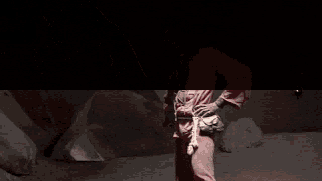 a man in a red robe is standing in a dark room
