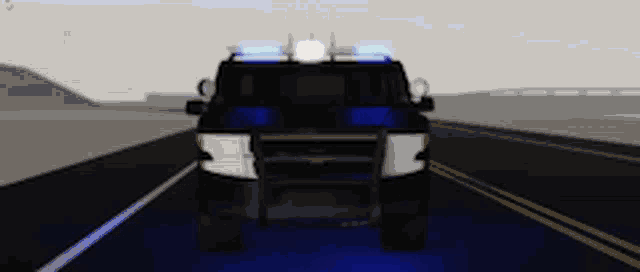 a police car is driving down a highway with blue lights on the roof .