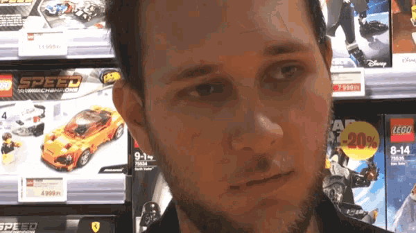a man is standing in front of a display of lego speed cars