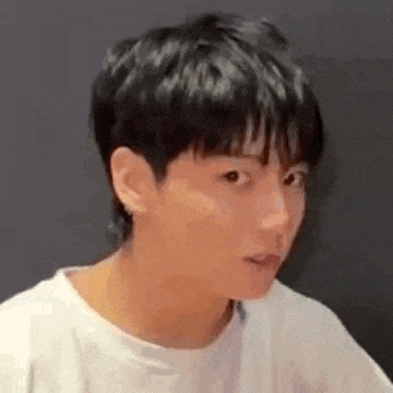 a close up of a person making a funny face while wearing a white shirt .