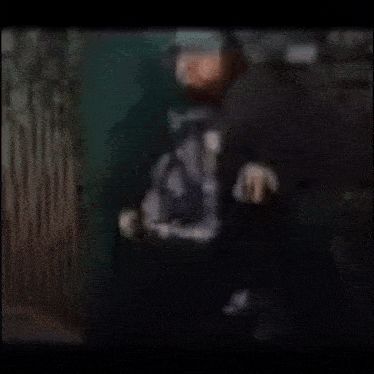 a blurry picture of a man wearing a black shirt that says ' a ' on it