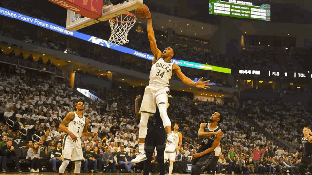 a basketball player with the number 34 on his jersey is jumping in the air
