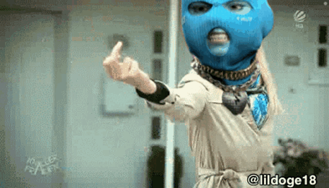 a woman wearing a blue ski mask and a trench coat giving the middle finger