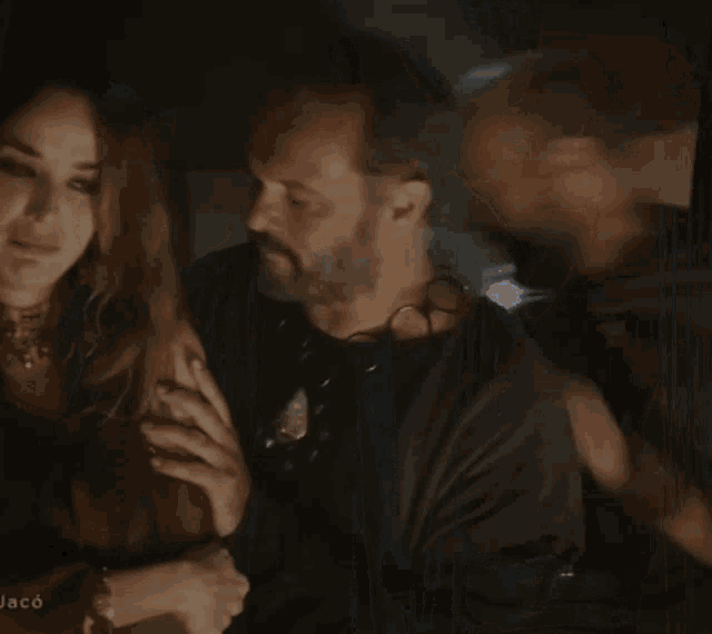 a man kisses a woman on the cheek in a dark room with the word jaco on the bottom