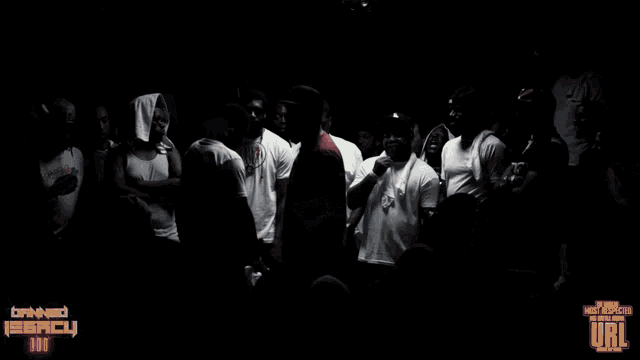 a group of men standing in a dark room with nunn nunn written on the bottom right