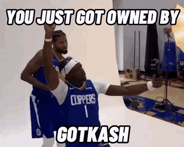 a man in a clippers jersey is taking a selfie with another man in a basketball uniform .