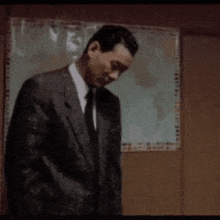 a man in a suit is standing in front of a map of the world