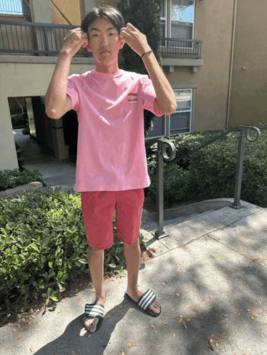 a young man wearing a pink shirt that says supreme