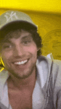 a man wearing a hat and a hoodie is smiling .