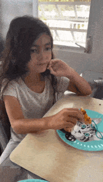 a little girl is sitting at a table eating a slice of pizza