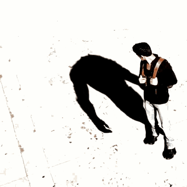a man with a backpack is standing in front of a shadow of a monster